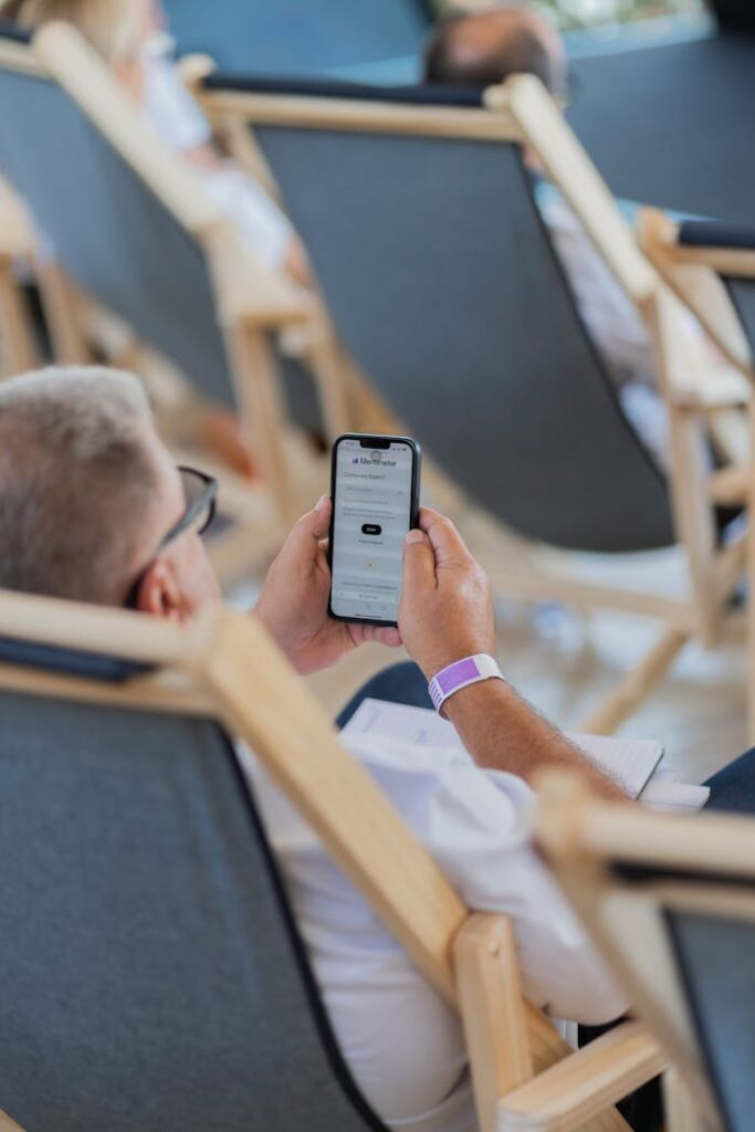 man-on-a-deckchair-browsing-the-website-on-his-phone-27220245